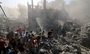 People search for survivors and the bodies of victims in the rubble of buildings destroyed during an Israeli bombardment