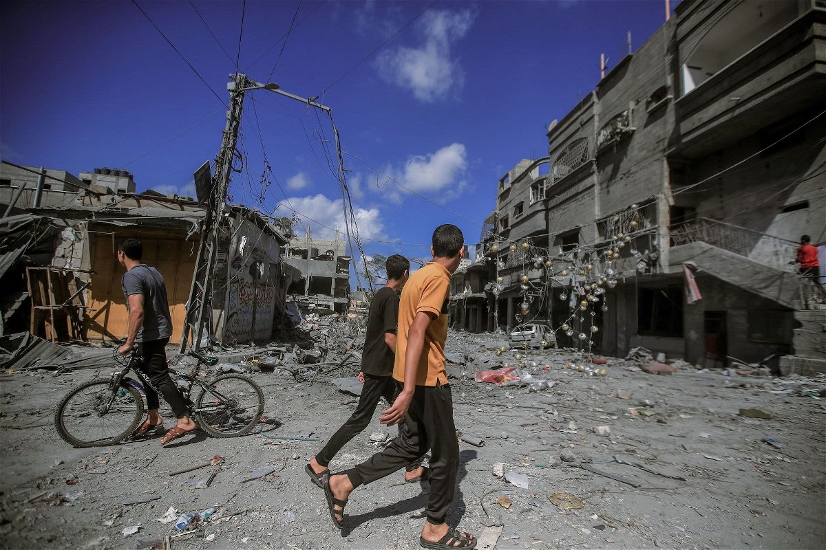 <i>Mohamed Zaanoun/Middle East Images/AFP/Getty Images</i><br/>People walk amid the destruction of houses and streets in Khan Younis