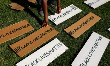 A protester picks up signs during a demonstration in Beverly Hills