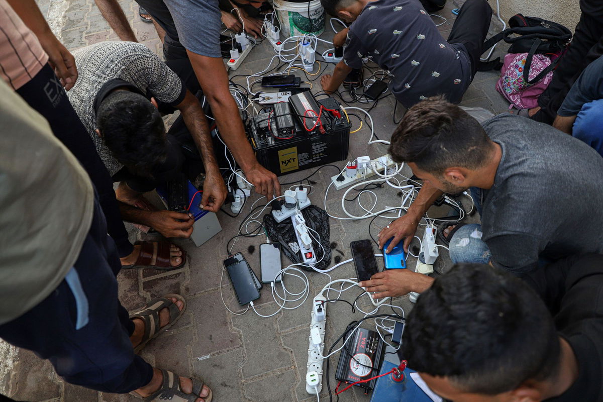 <i>Rizek Abdeljawad/Xinhua/Getty Images</i><br/>Palestinians struggle to charge and use their mobile phones amid electricity cuts and telecommunication blackouts across Gaza.