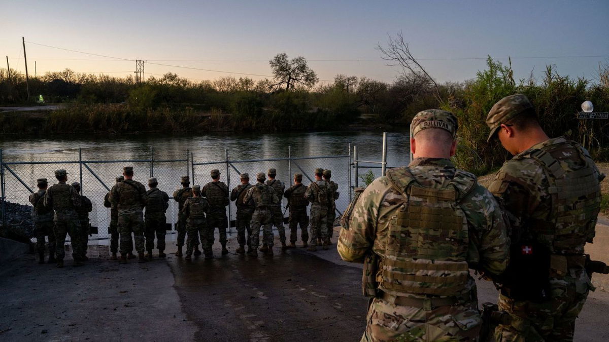 National Guard soldiers stand guard Friday on the banks of the Rio Grande river at Shelby Park in Eagle Pass, Texas.
