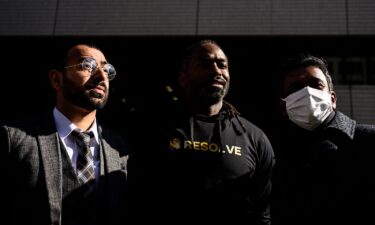 The three plaintiffs and their legal team walk outside the Tokyo District Court on January 29