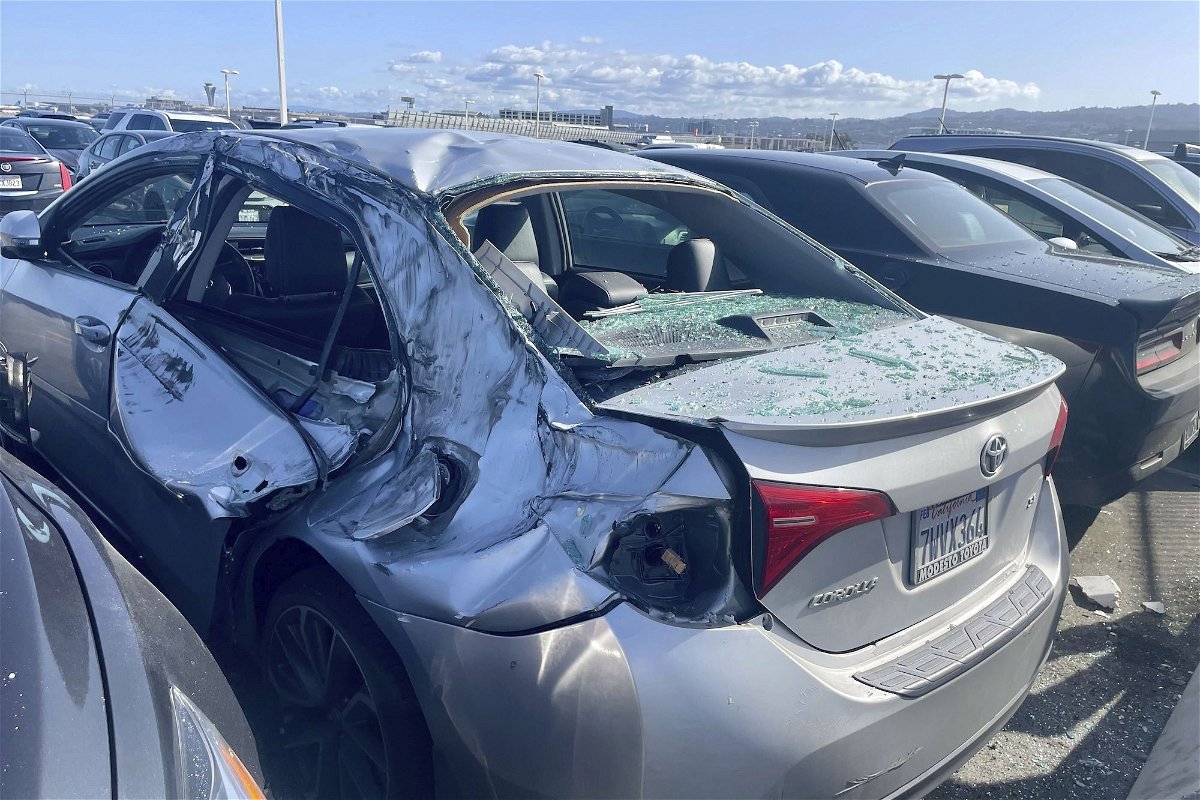 <i>Haven Daley/AP via CNN Newsource</i><br/>A damaged car is seen in an employee parking lot after tire debris from a United Airlines plane landed on it at San Francisco International Airport.