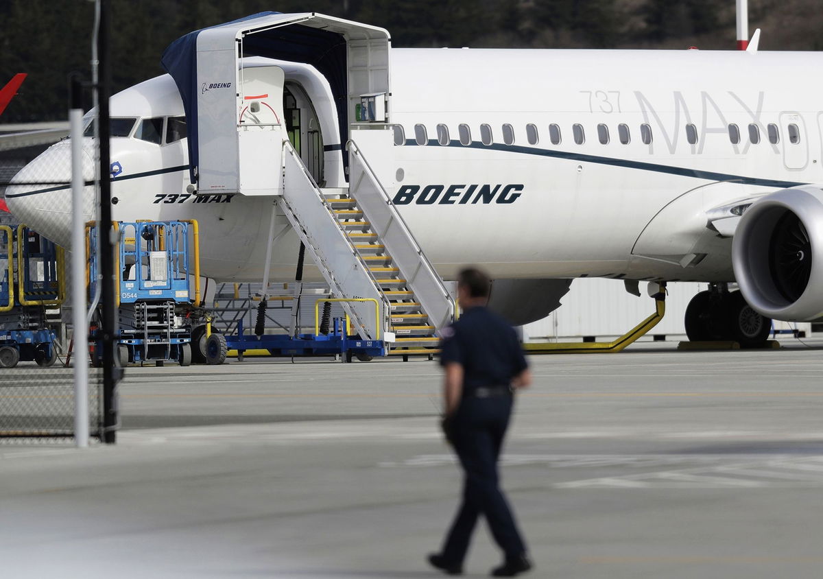 <i>Ted S. Warren/AP via CNN Newsource</i><br />A worker walks next to a Boeing 737 MAX 8 airplane parked at Boeing Field in Seattle