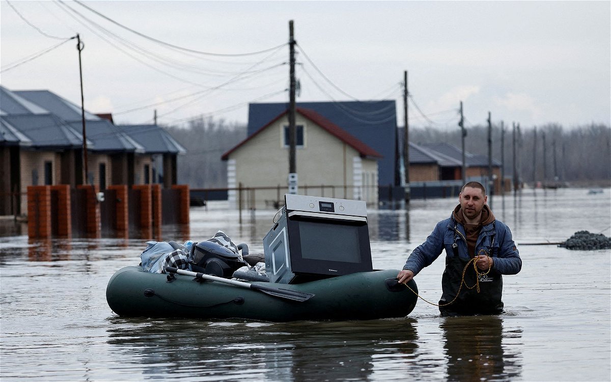 <i>Maxim Shemetov/Reuters via CNN Newsource</i><br/>Residents and Russian Emergencies Ministry rescuers ride boats in a flooded street in Orenburg