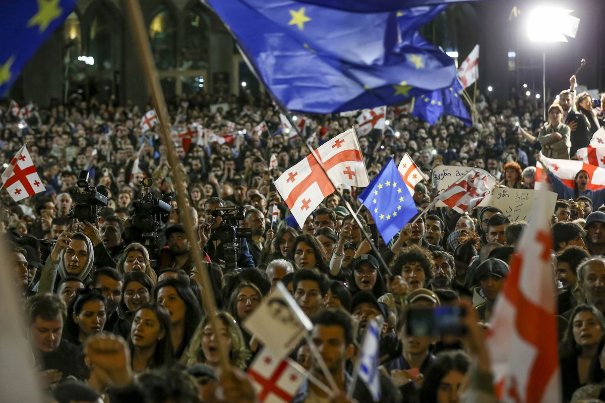 <i>Irakli Gedenidze/Reuters via CNN Newsource</i><br/>A protester draped in an European Union flag confronts riot police in Tbilisi