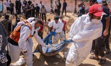 Palestinian health workers recover buried bodies from a mass grave at the Nasser Medical Hospital compound in Khan Younis
