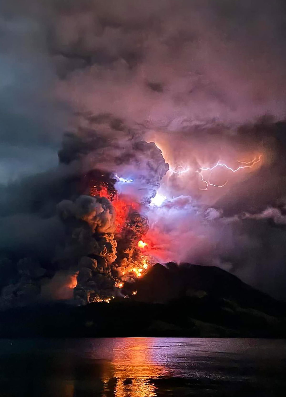 <i>Ronny Adolof Buol/AFP/Getty Images via CNN Newsource</i><br/>Police officers sweep volcanic material accumulated on the ground