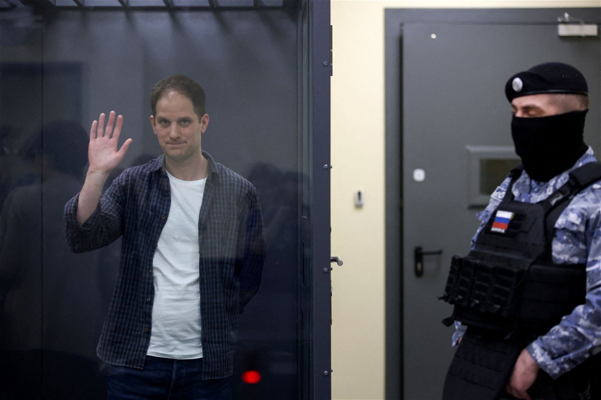 <i>Tatyana Makeyeva/Reuters via CNN Newsource</i><br/>Wall Street Journal reporter Evan Gershkovich waves behind a glass wall of an enclosure for defendants in Moscow