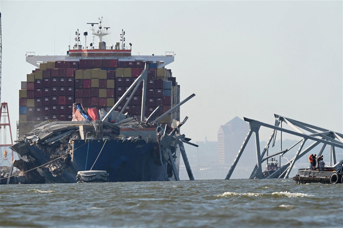 <i>Roberto Schmidt/AFP/Getty Images via CNN Newsource</i><br/>A section of the Francis Scott Key Bridge rests in the water next to the Dali container ship in Baltimore on May 13