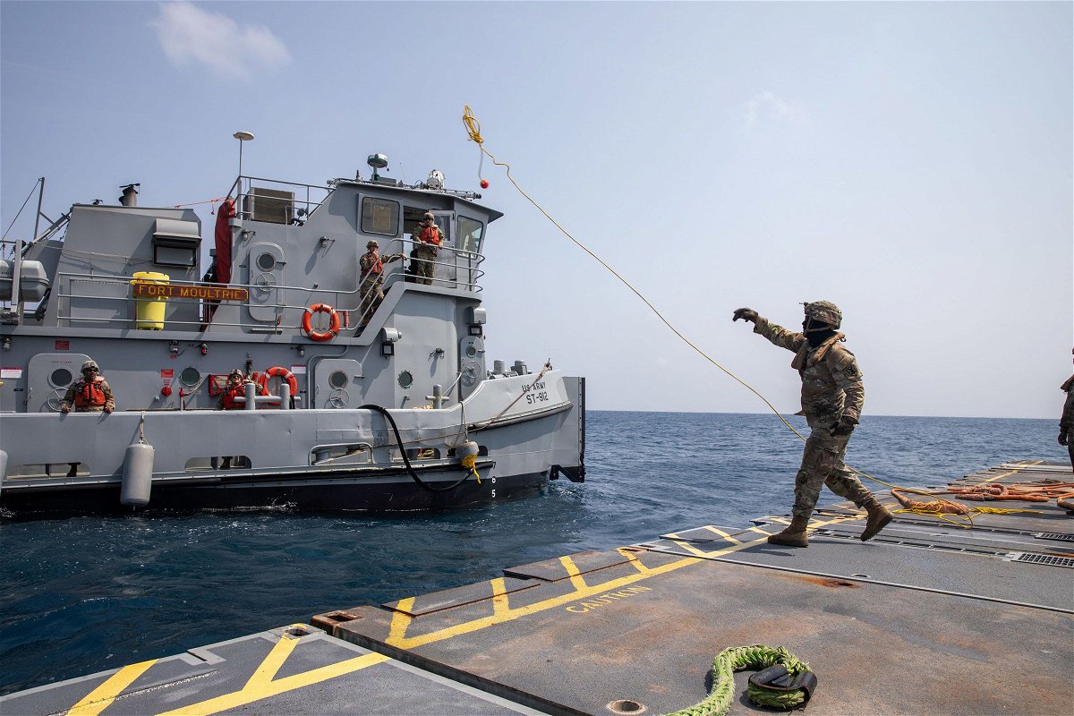 A U.S. Army Soldier tosses a line to an Army tug vessel from the Roll-On, Roll-Off Distribution Facility, or floating pier, off the shore of Gaza on May 1.