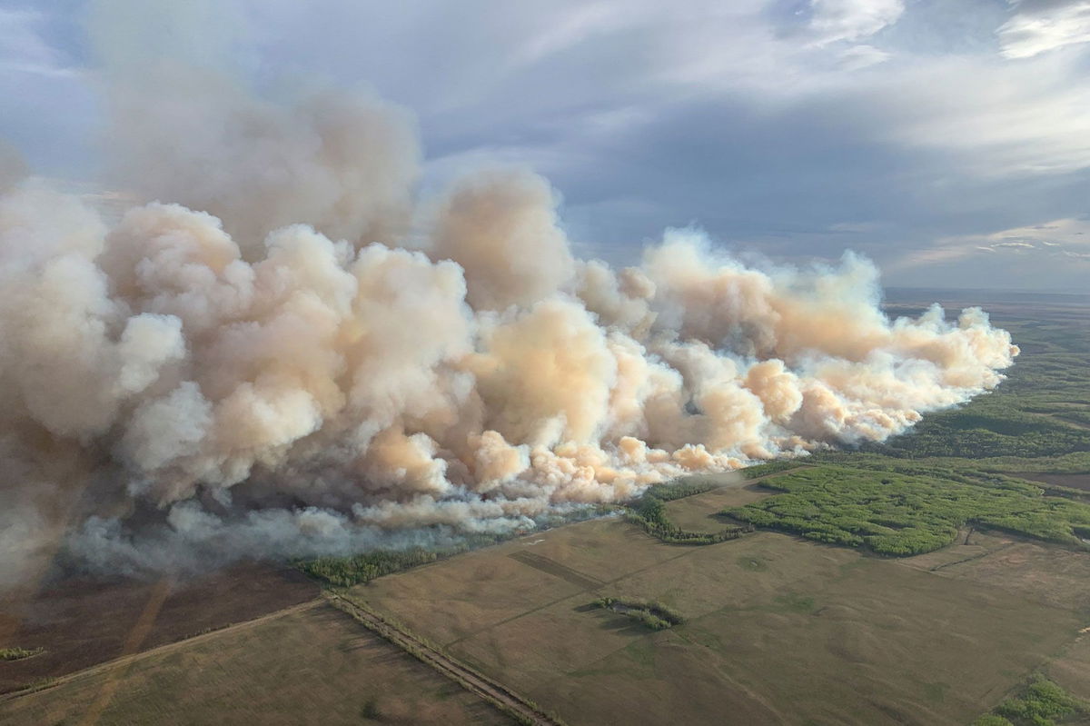 <i>Jason Franson/The Canadian Press/AP via CNN Newsource</i><br/>Smoke from wildfires blankets the city as a couple has a picnic in Edmonton