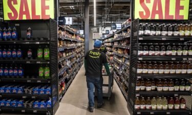 Workers stock shelves at an Amazon Fresh grocery store in Seattle