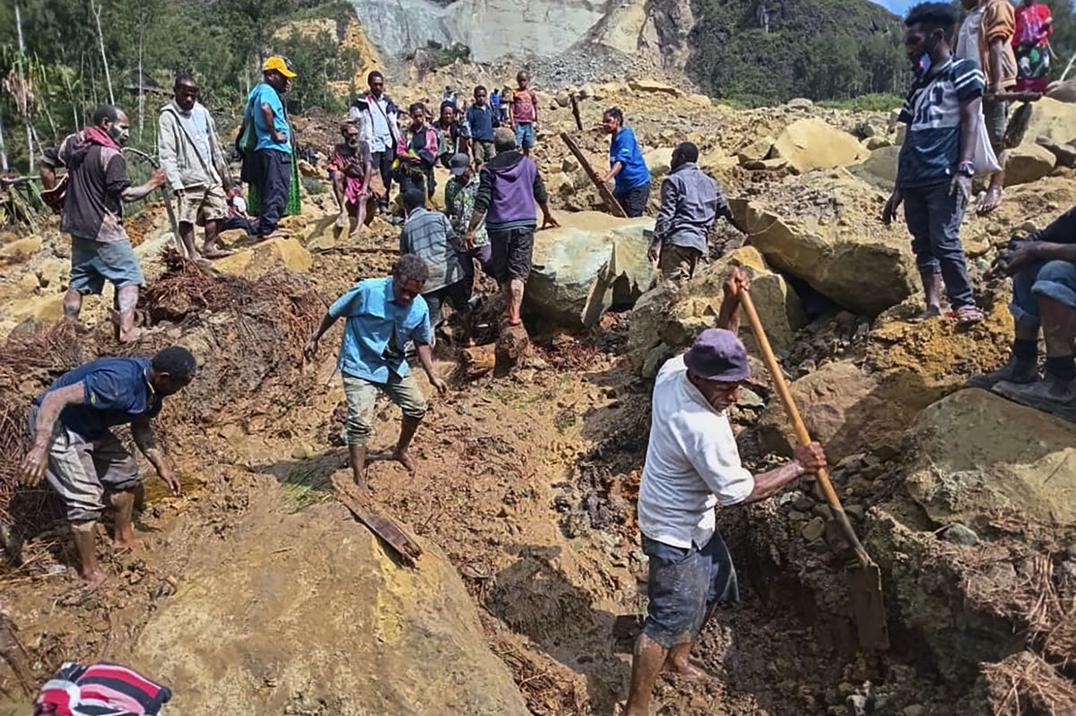 Villagers search through a landslide in Yambali, in the Highlands of Papua New Guinea, Sunday, May 26.