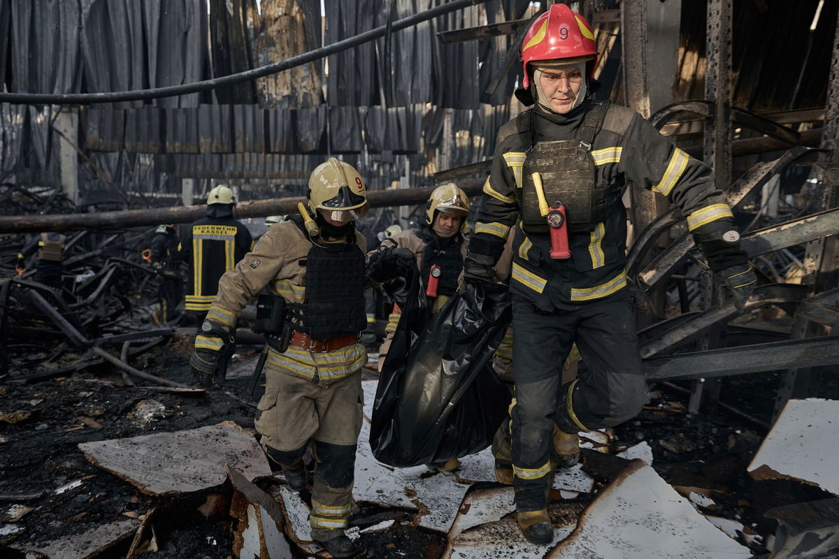 <i>Kostiantyn Liberov/Libkos/Getty Images via CNN Newsource</i><br/>Emergency workers carry out the body of a victim of a Russian strike that hit a large store in Kharkiv.