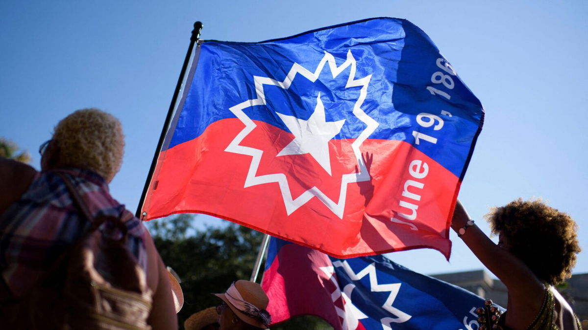 <i>Mark Felix/AFP/Getty Images via CNN Newsource</i><br/>People wave a Juneteenth flag during a celebration in Galveston