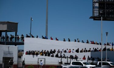 Asylum seekers walk for their asylum interview appointment with US authorities at the El Chaparral crossing port in Tijuana