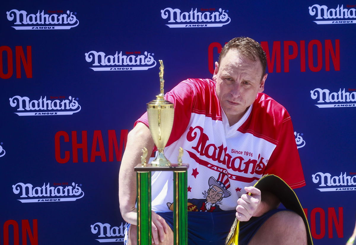 <i>Kena Betancur/Getty Images via CNN Newsource</i><br />Joey Chestnut sits with the trophy and belt after he won first place