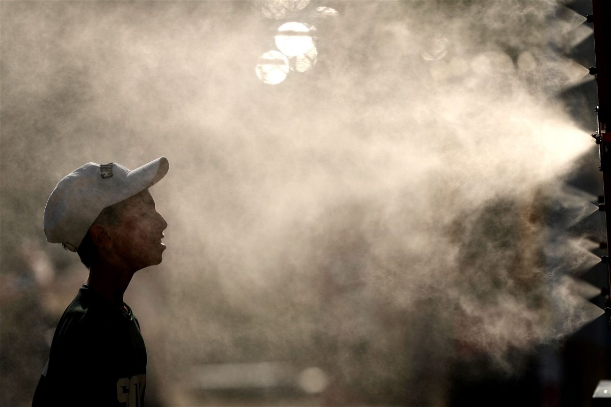 <i>Charlie Riedel/AP via CNN Newsource</i><br/>A fan cools off in a mister before a baseball game between the Kansas City Royals and the New York Yankees