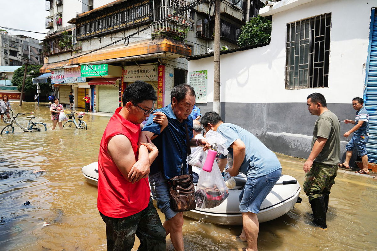 <i>John Ricky/Anadolu/Getty Images via CNN Newsource</i><br/>Villager walks on muddy streets as torrential rains cause flooding on June 19 in Meizhou