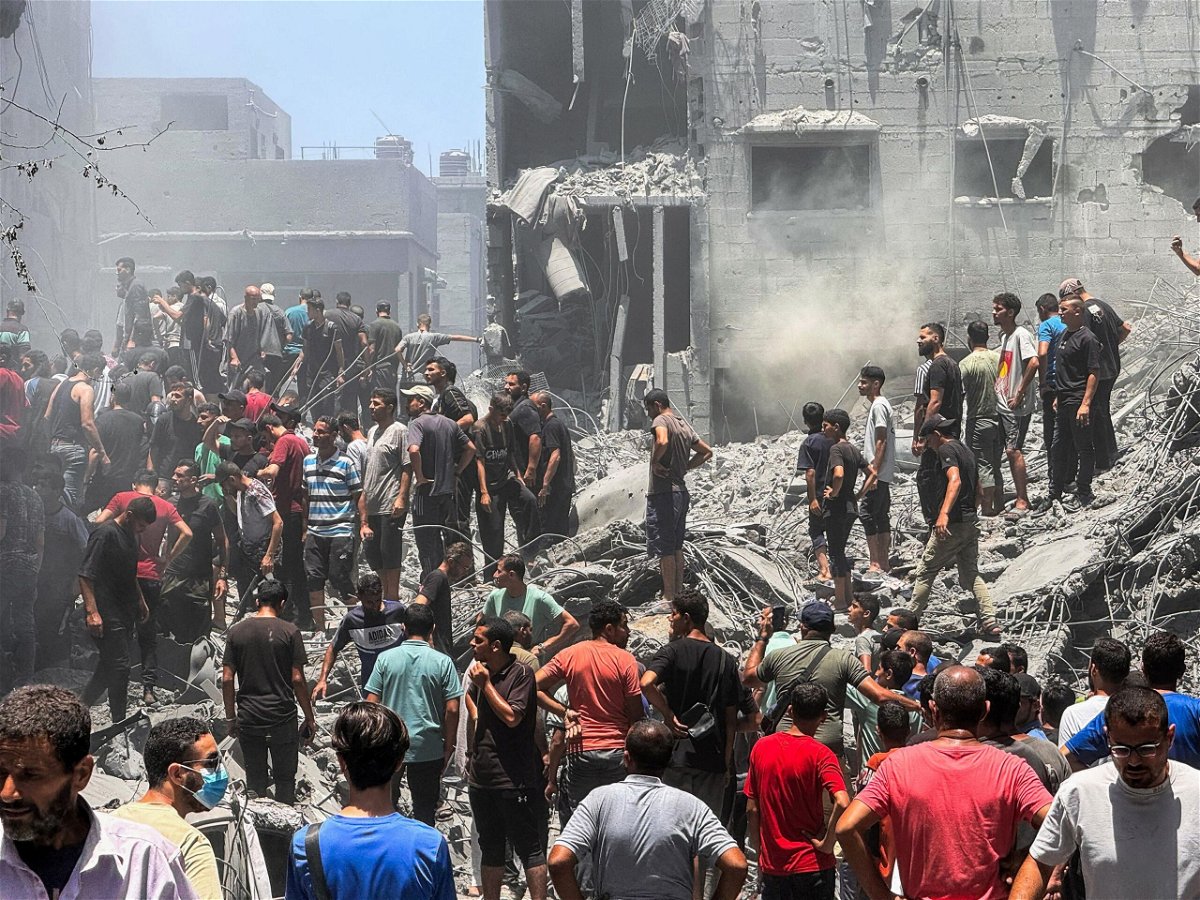 <i>Ayman Al Hassi/Reuters via CNN Newsource</i><br/>Palestinians search for casualties in Gaza City.