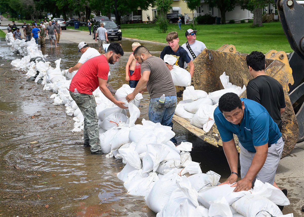 <i>Tim Hynds/Sioux City Journal/AP via CNN Newsource</i><br/>Volunteers stack sandbags in the wake of flooding from the Big Sioux River