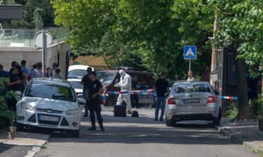 Police officers work at the crime scene close to the Israeli embassy in Belgrade on June 28.