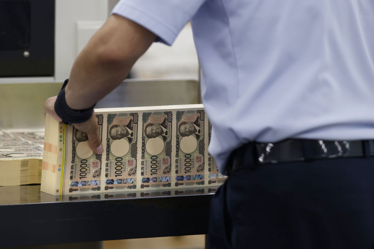 <i>Kiyoshi Ota/Bloomberg/Getty Images via CNN Newsource</i><br/>An employee handles sheets of newly-designed Japanese 10