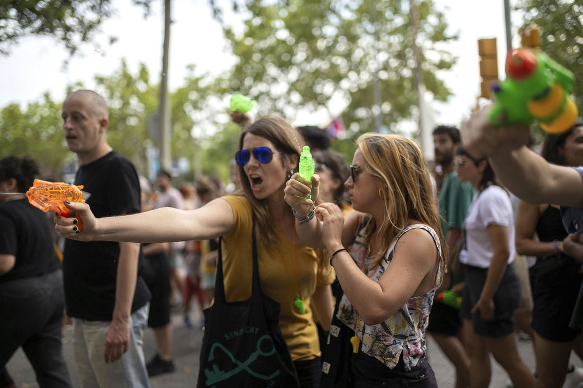 <i>Josep Lago/AFP/Getty Images via CNN Newsource</i><br/>Diners cower as protesters march past a restaurant.