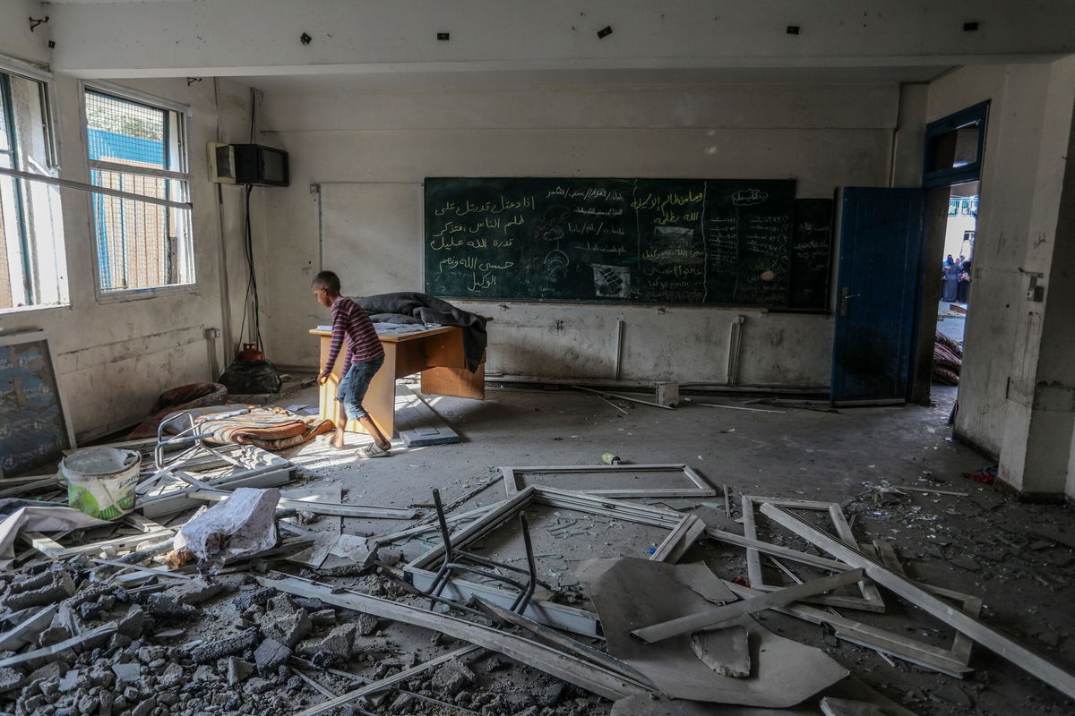 <i>Abed Rahim Khatib/Anadolu/Getty Images via CNN Newsource</i><br/>Palestinians and UN workers examine the destroyed UNRWA school in Nuseirat refugee camp of Deir al-Balah