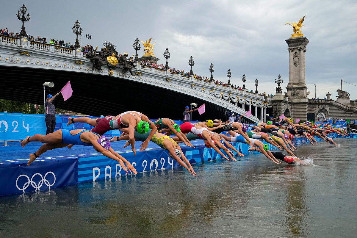 <i>Vadim Ghirda/AP via CNN Newsource</i><br />Athletes dive into the water for the start of the women's individual triathlon competition on July 31 in Paris.