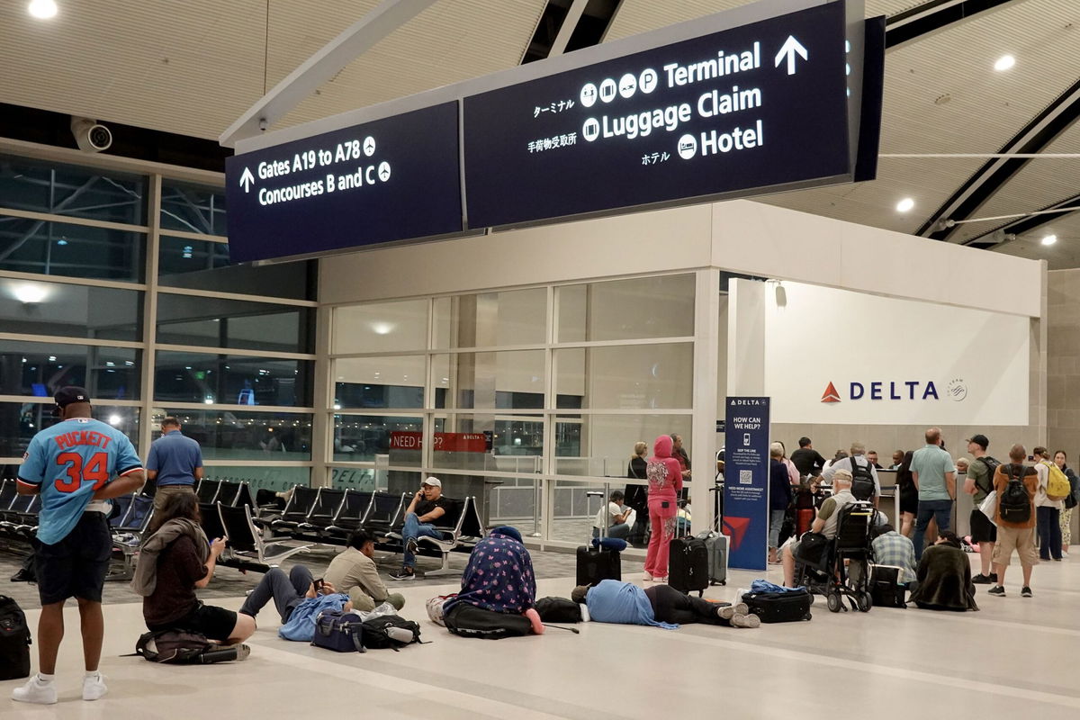 <i>Joe Raedle/Getty Images via CNN Newsource</i><br/>Travelers wait in a long line to speak with a Delta representative at the help desk in the McNamara terminal at the Detroit Metropolitan Wayne County Airport on July 20.