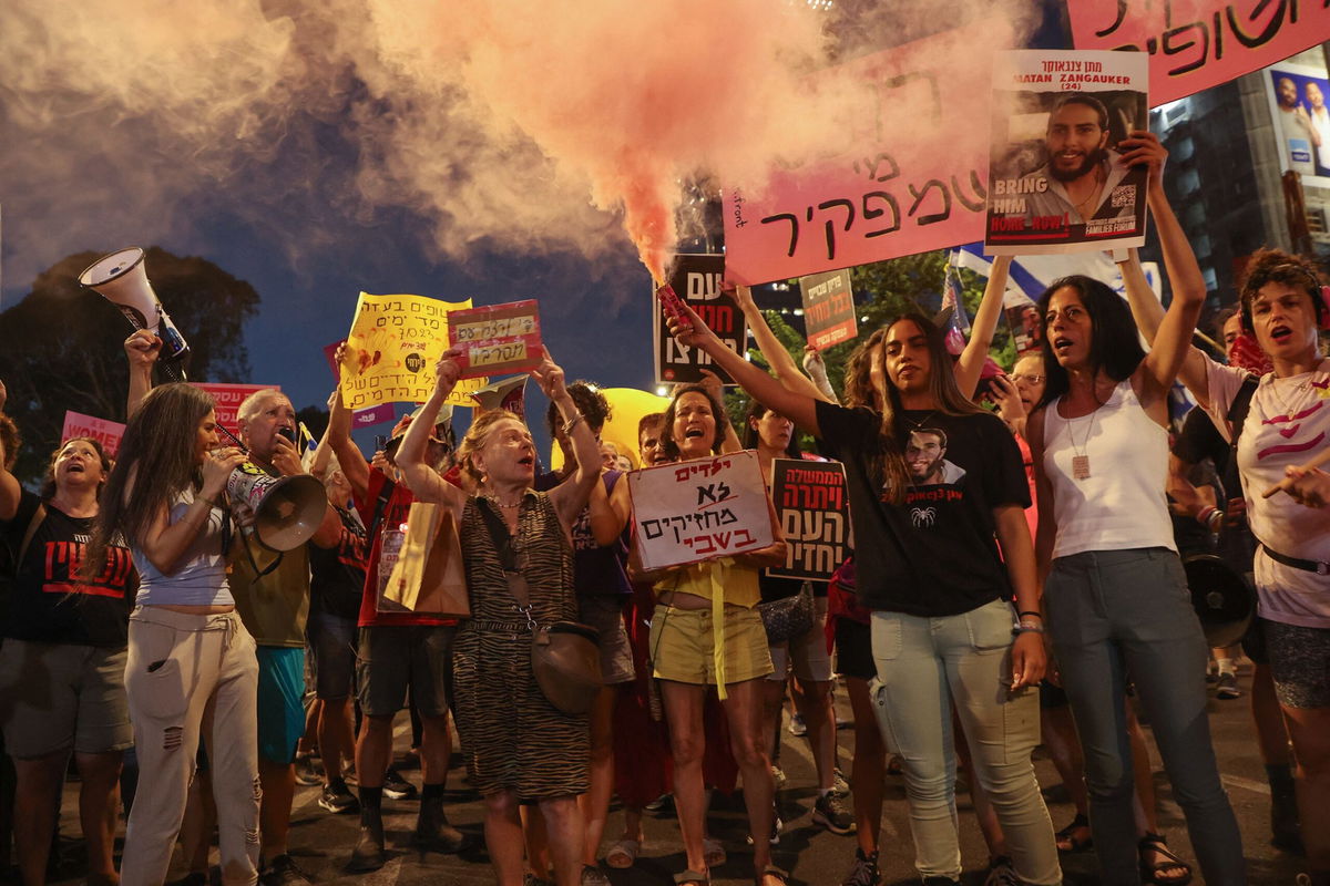 <i>Gil Cohen-Magen/AFP/Getty Images via CNN Newsource</i><br/>Supporters and relatives of Israelis held hostage by Palestinian militants in the Gaza Strip since October lift placards during a rally to demand their release in Tel Aviv on August 3.