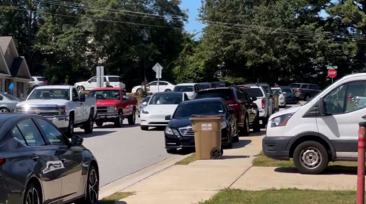 A line of cars park about half a mile from Apalachee High School.