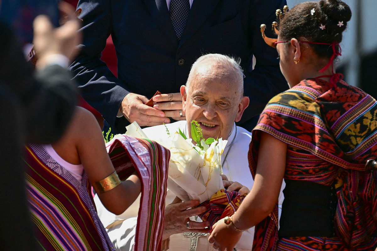 <i>Guglielmo Mangiapane/Reuters via CNN Newsource</i><br/>Pope Francis wears a scarf he was presented with when he arrived in Dili