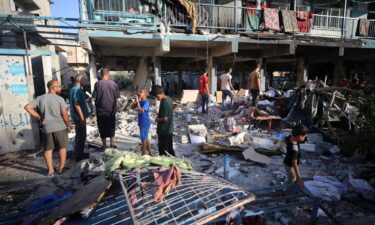 Palestinians check the grounds of a school after an Israeli airstrike in Nuseirat