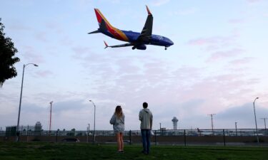 People view a Southwest Airlines plane landing from a park next to Los Angeles International Airport. For a limited time