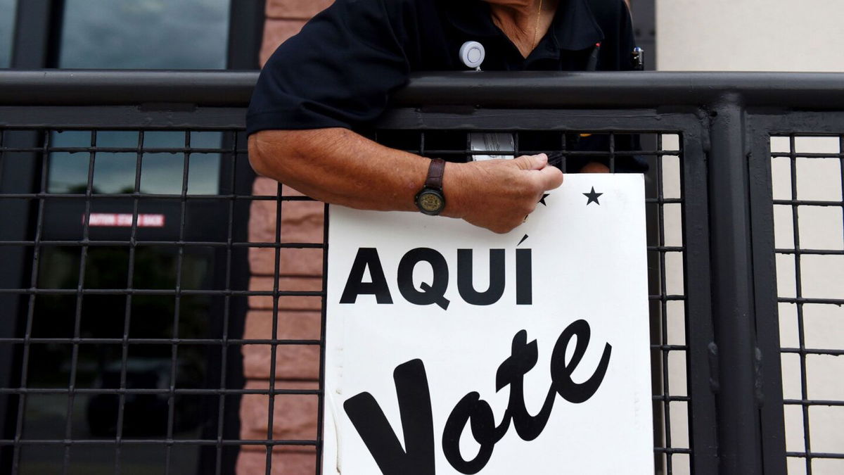 <i>Callaghan O'Hare/Bloomberg/Getty Images via CNN Newsource</i><br/>A Bexar County employee sets up signs during early voting at a polling location in San Antonio