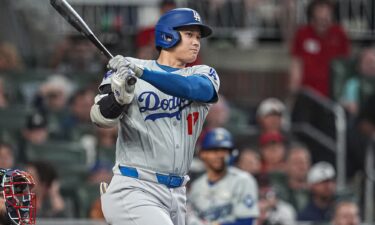 Los Angeles Dodgers designated hitter Shohei Ohtani doubles to drive in a run against the Atlanta Braves during the fifth inning at Truist Park.