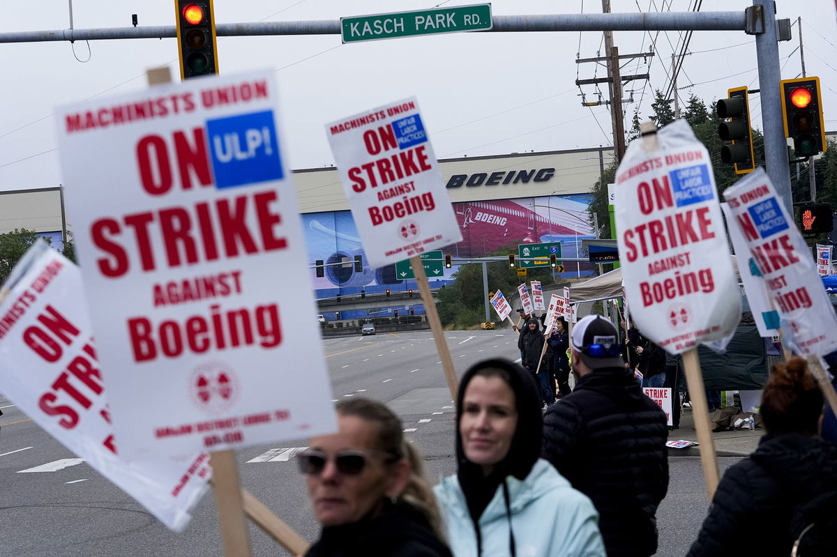 <i>Lindsey Wasson/AP via CNN Newsource</i><br/>Boeing workers wave picket signs as they strike on September 15