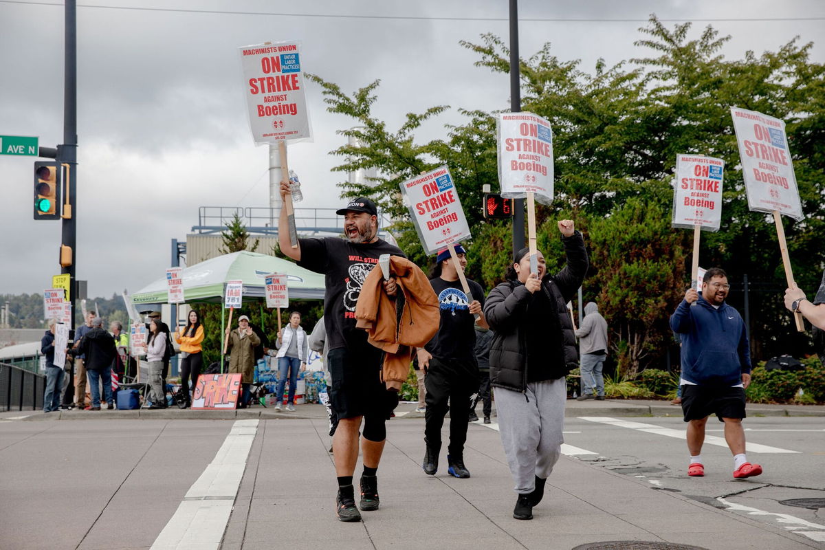 <i>Yehyun Kim/AFP/Getty Images via CNN Newsource</i><br/>Striking workers and their supporters picket outside the Boeing manufacturing facility in Renton