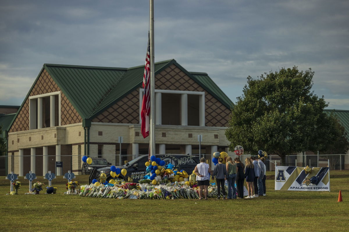 <i>The Washington Post/Getty Images/File via CNN Newsource</i><br/>People pay respects at a memorial to the shooting victims at Apalachee High School.