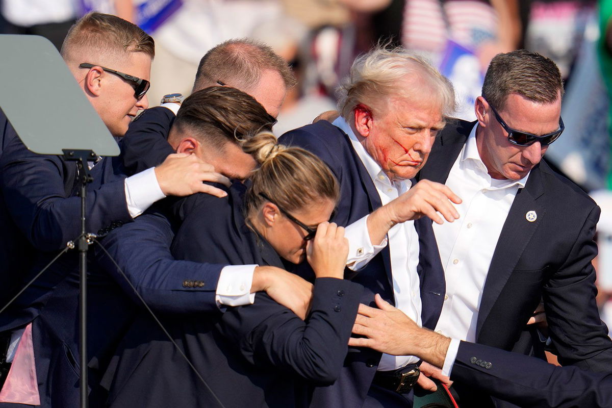 <i>Gene J. Puskar/AP/File via CNN Newsource</i><br/>Republican presidential candidate former President Donald Trump is helped off the stage by US Secret Service agents at a campaign event in Butler