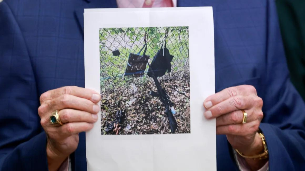 Palm Beach County Sheriff Ric Bradshaw holds a photograph of the rifle and other items found near where a suspect was discovered during a press conference on Sunday. Joe Raedle/Getty Images