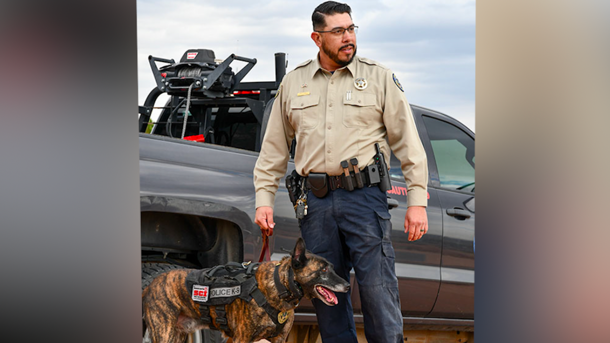 DWM Phil Gurule walked his K-9 partner, Sci, to their patrol truck for the dog's 