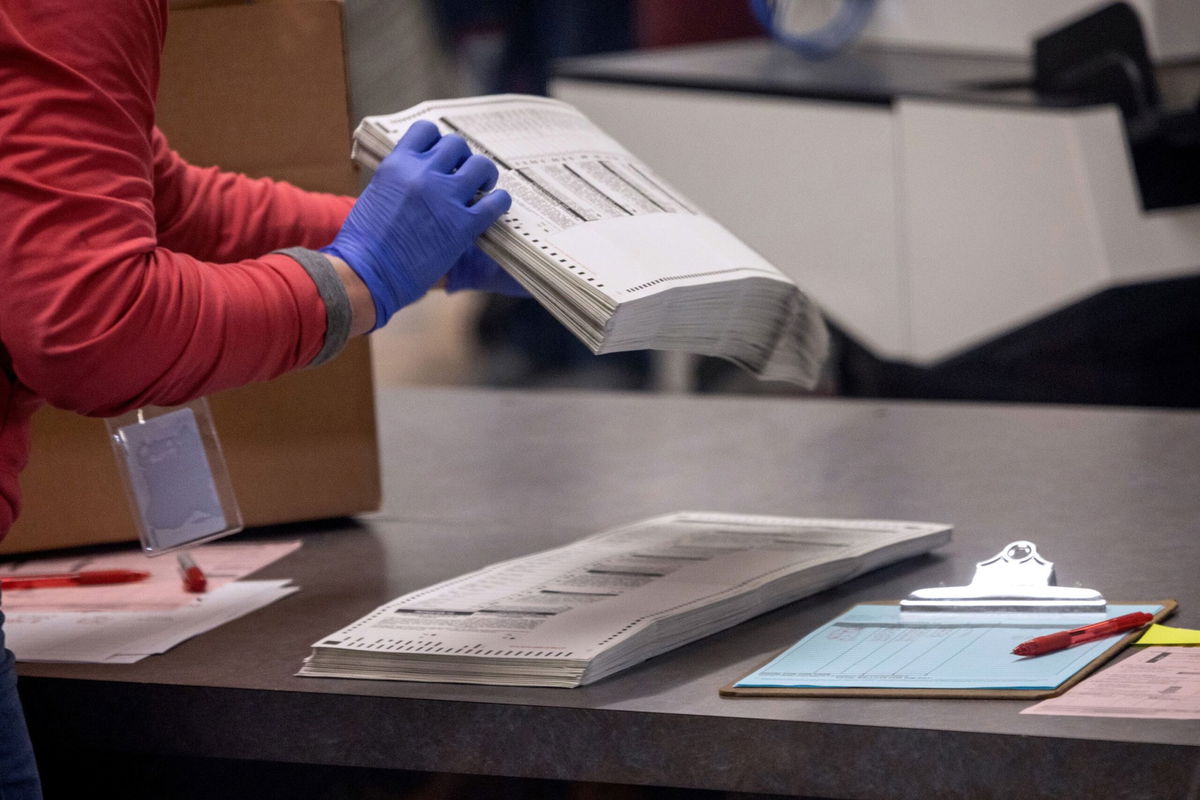 <i>John Moore/Getty Images via CNN Newsource</i><br/>Election workers sort ballots at the Maricopa County Tabulation and Election Center in November 2022 in Phoenix