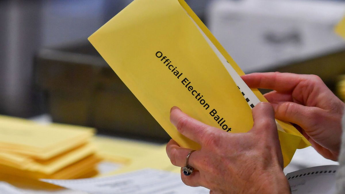 <i>CNN via CNN Newsource</i><br/>Wake County Board of Elections member Keith Weatherly signs a box of mail-in ballots at the Wake County Board of Elections ballot processing center in Raleigh