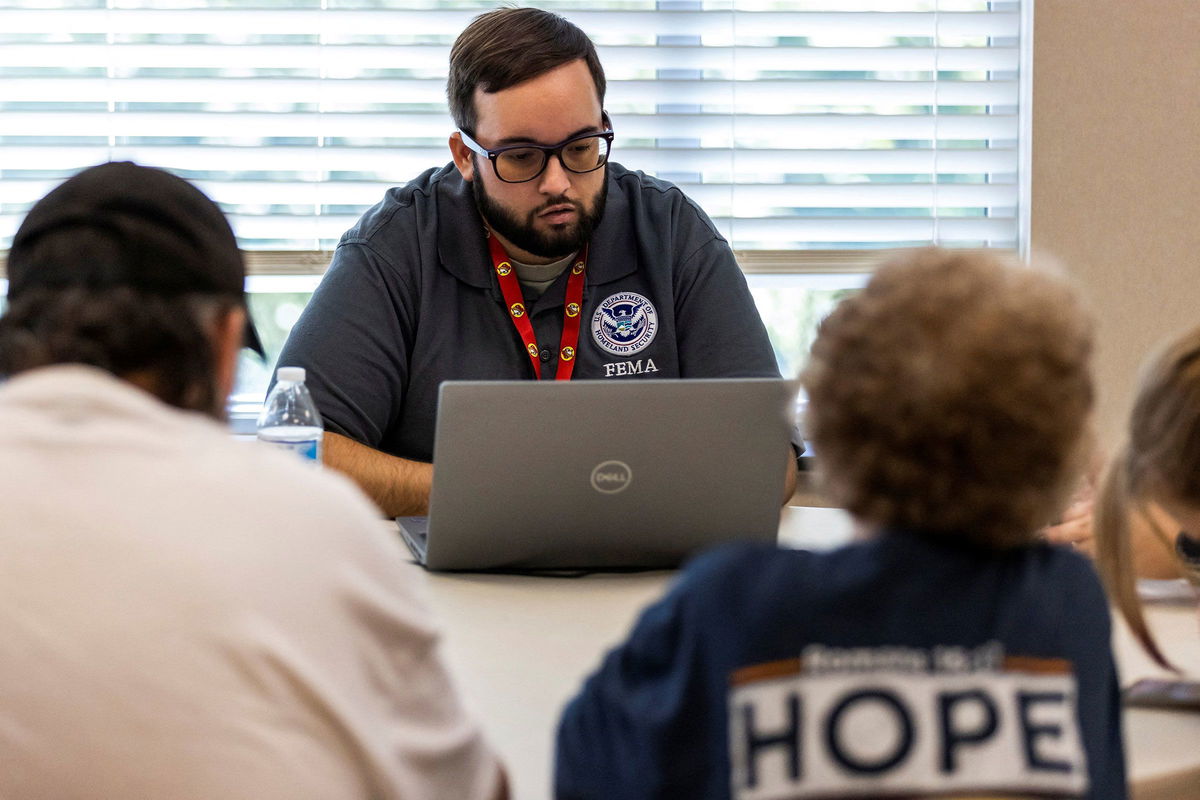 <i>Eduardo Munoz/Reuters via CNN Newsource</i><br/>A FEMA worker attends claims by local residents after being affected by floods following the passing of Hurricane Helene