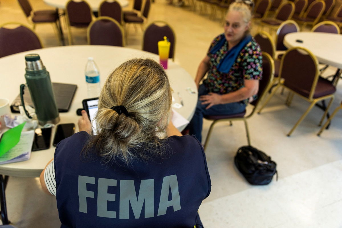 <i>Eduardo Munoz/Reuters via CNN Newsource</i><br/>A FEMA worker attends a claim by a local resident after being affected by floods following the passing of Hurricane Helene