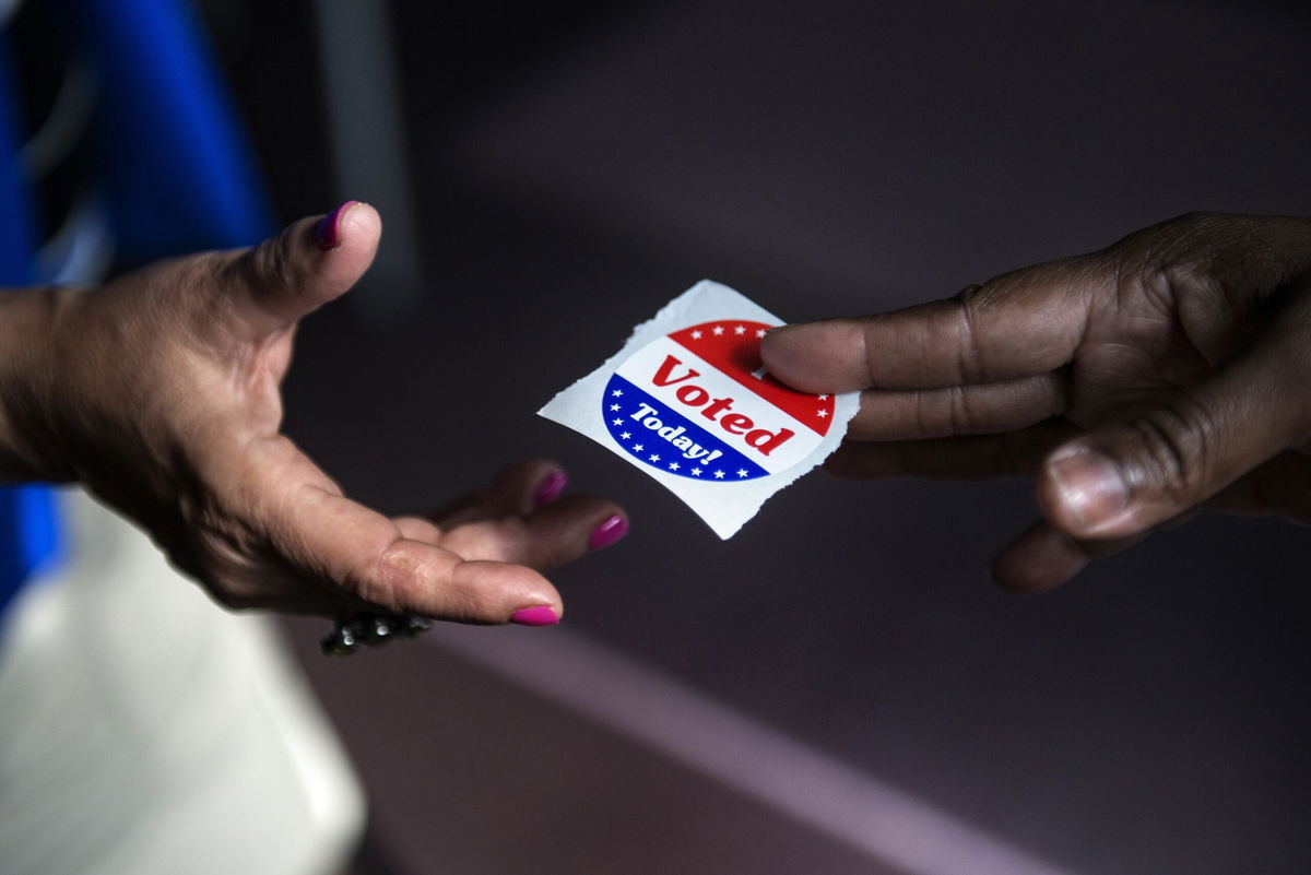 <i>AFP/Getty Images via CNN Newsource</i><br/>A poll worker hands out 